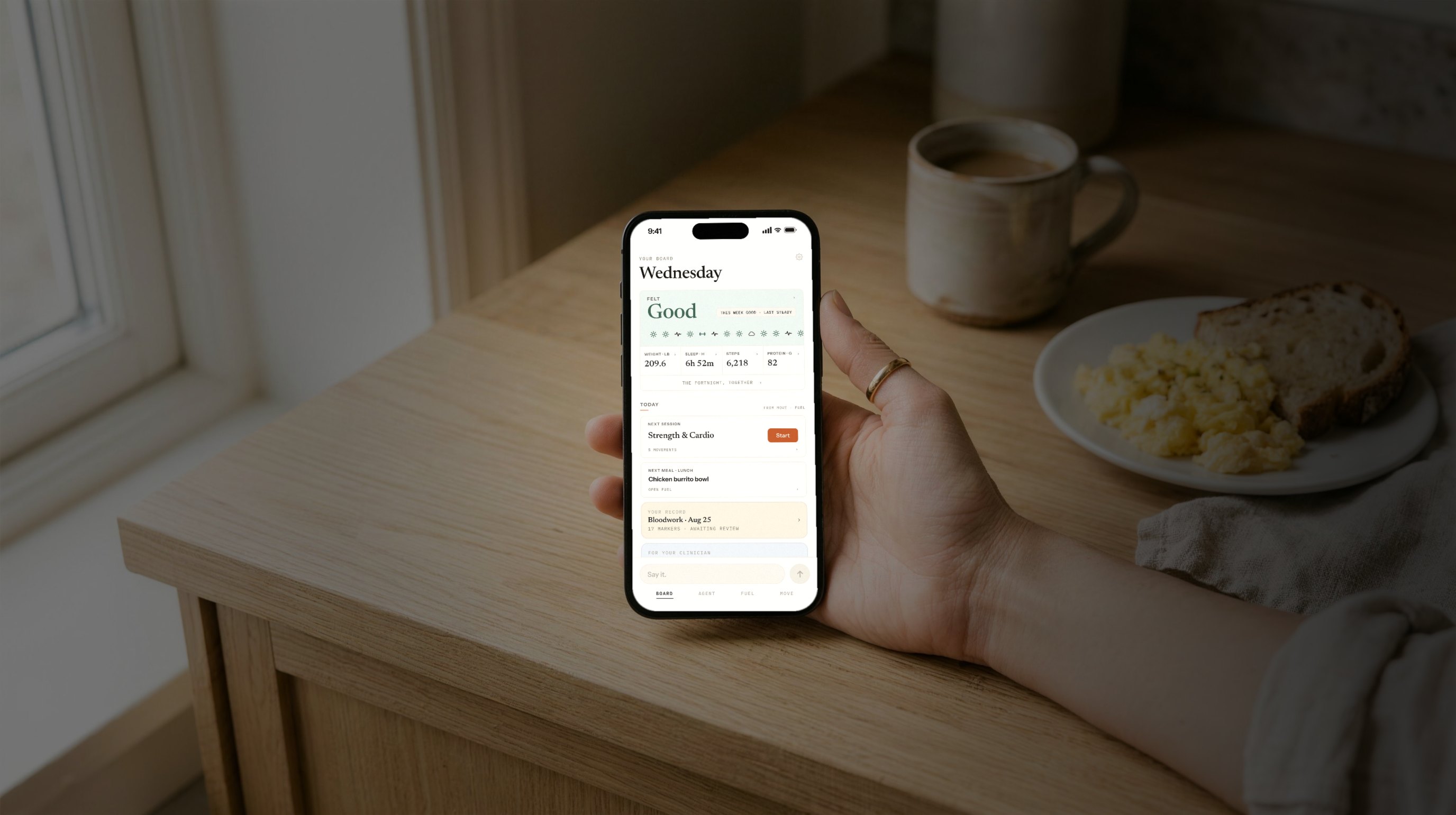 The Welling app in hand at a kitchen counter in the morning